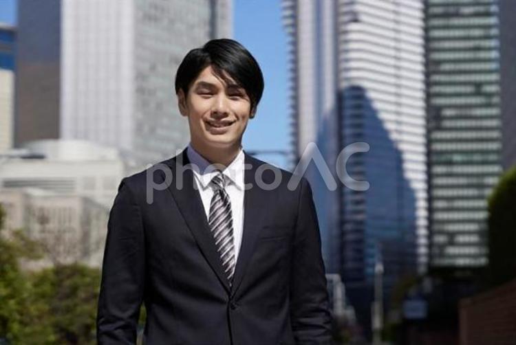 オフィス街で笑顔で立つビジネスマン ビジネスマン,男性,笑顔の写真素材