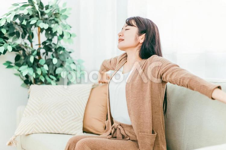 ソファで深呼吸する日本人女性（起床） 女性,深呼吸,ソファの写真素材