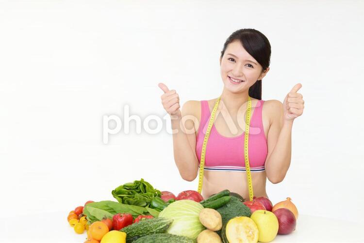 ダイエットに成功した笑顔の女性 女性,野菜,果物の写真素材
