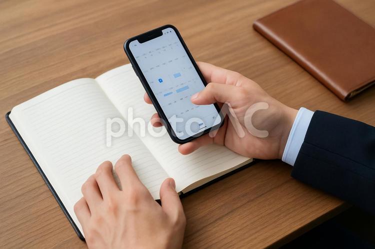スマートフォンで予定を確認する手元 ビジネス,手元,スマホの写真素材