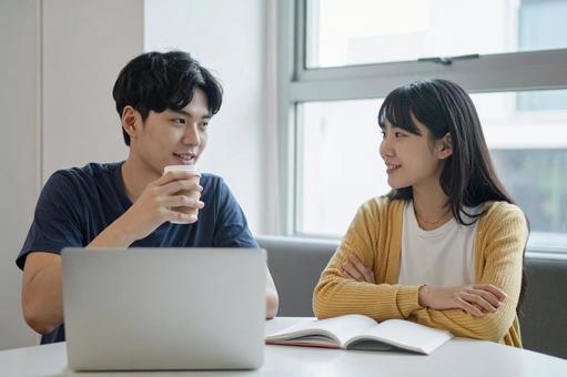 大学のゼミの研究室で会話する男女 大学のゼミの研究室で会話する男女の写真
