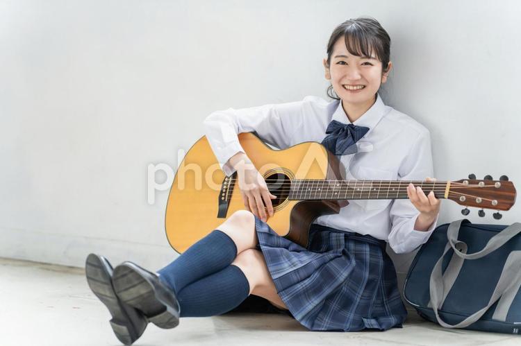 ギターを弾く軽音部・吹奏楽部の高校生 高校生,友達,ギターの写真素材