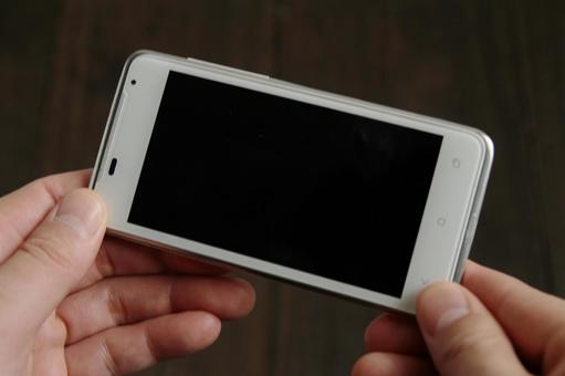 スマートフォンを持つ手 スマートフォンを持つ手の写真