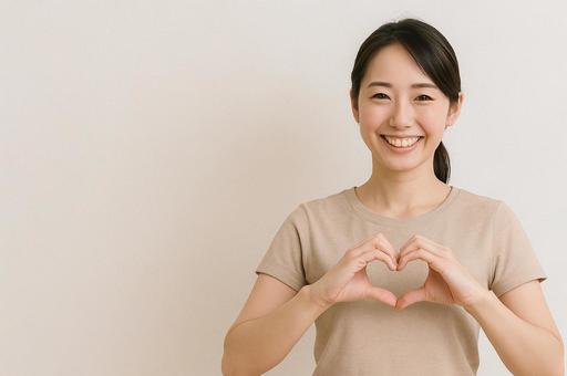 手でハートを作る笑顔の人 手でハートを作る笑顔の人の写真