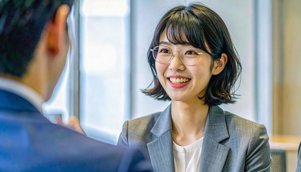 笑顔で話すスーツ姿の女性の写真