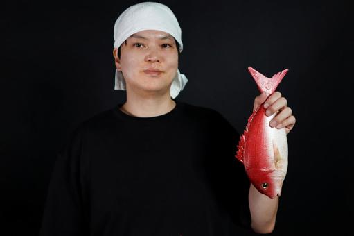 赤い魚を持つ男性 赤い魚を持つ男性の写真