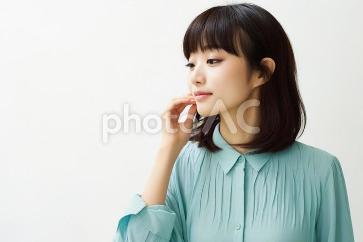 頬に手をあてる女性 女性,女の人,女子の写真素材