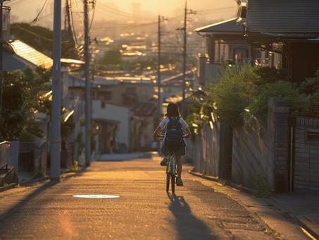 自転車で家に帰る少女 自転車で家に帰る少女の写真