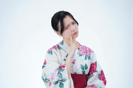 浴衣姿の女性が顎に手を当てて考える 女性,浴衣,考えるの写真素材
