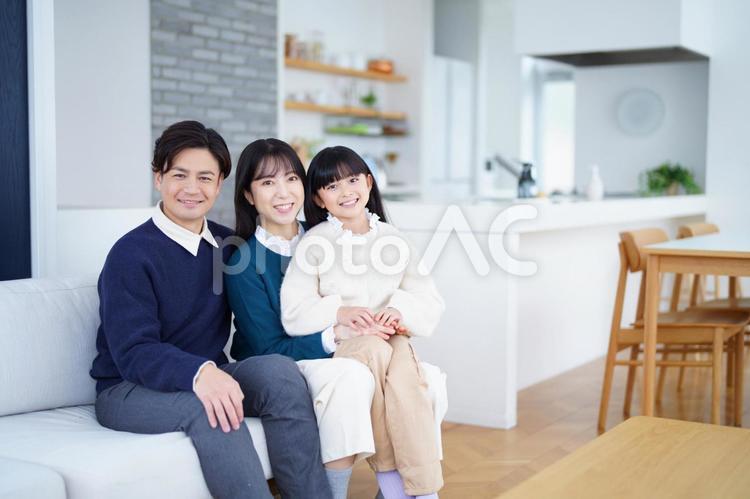 カメラ目線でソファーに座った家族と食卓 家族,女の子,女性の写真素材