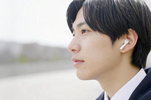 ワイヤレスイヤホンで音楽を聴く男性 ワイヤレスイヤホンで音楽を聴く男性の写真