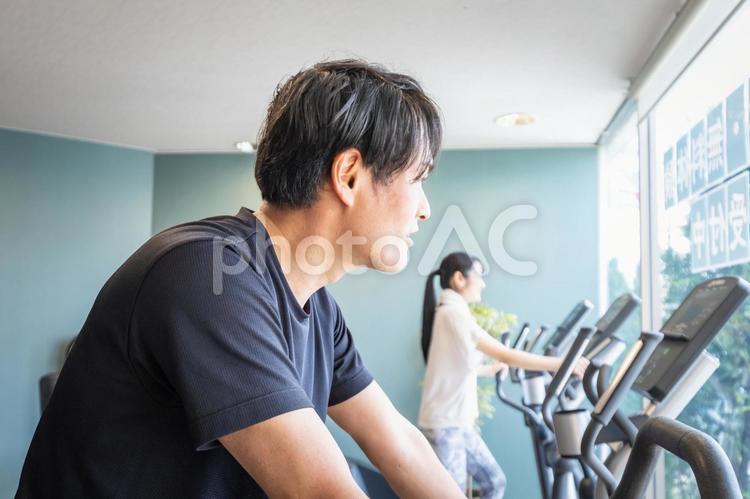 エアロバイクで運動する男性 エアロバイク,有酸素運動,スポーツジムの写真素材