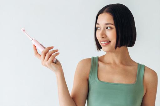 電動歯ブラシを持って遠くを見ている女性 電動歯ブラシを持って遠くを見ている女性 女性,歯ブラシ,電動の写真素材