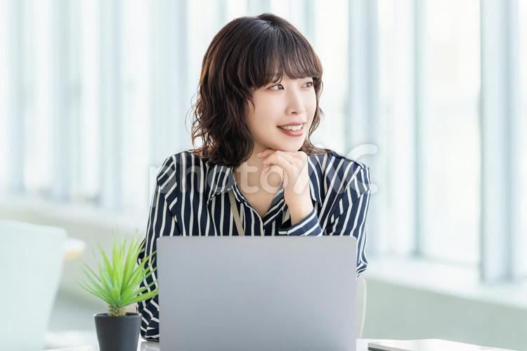 デスクワークをする笑顔のビジネスウーマン 女性,パソコン,ビジネスの写真素材