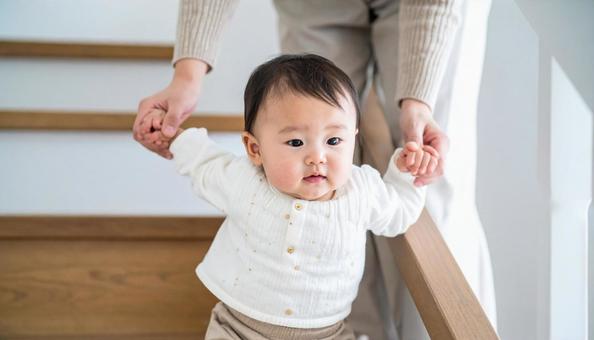 階段を下りるのが楽しい子供と見守る母親 階段を下りるのが楽しい子供と見守る母親の写真