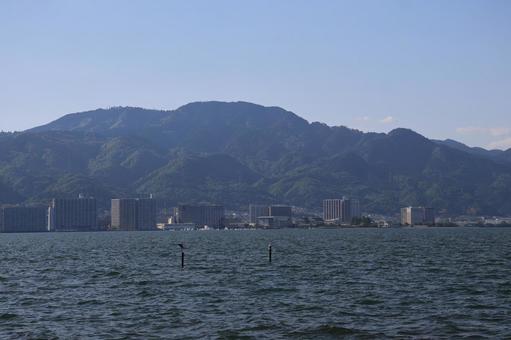 琵琶湖の湖面と街並みと山と空の風景 琵琶湖の湖面と街並みと山と空の風景の写真