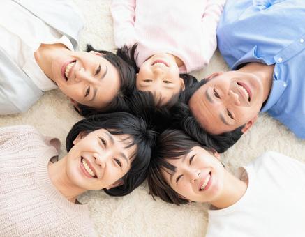 放射線状に寝転がって笑顔の日本人家族 放射線状に寝転がって笑顔の日本人家族の写真