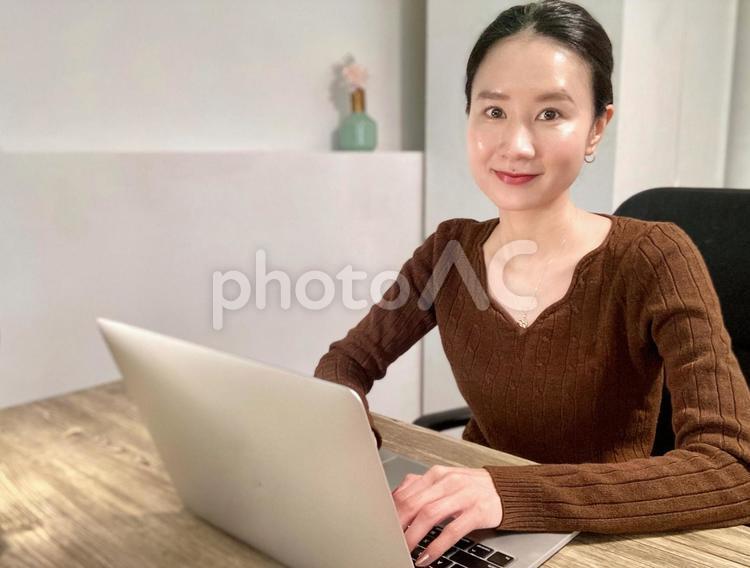 笑顔で在宅勤務をする社会人女性 女性,笑顔,パソコンの写真素材
