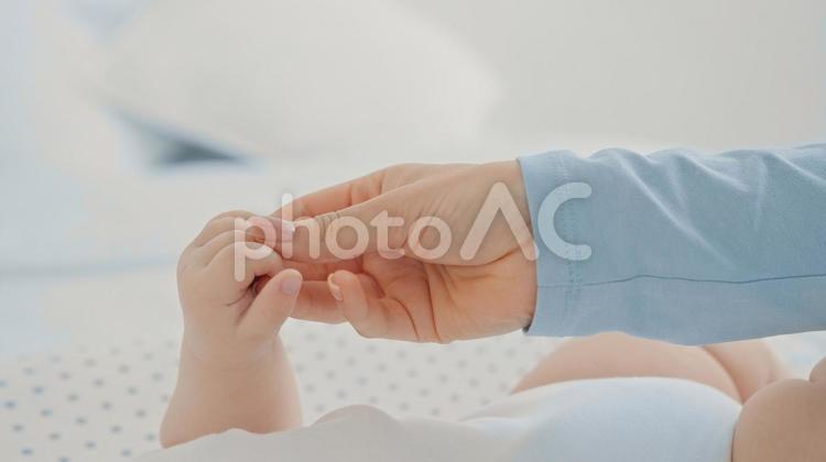 赤ちゃんの手を触る大人の手 指,握る,掴むの写真素材