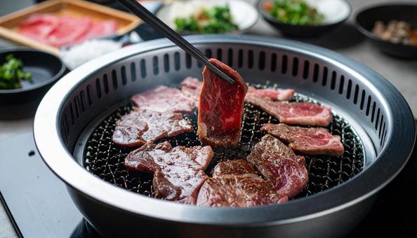 焼肉を鉄板で焼いて箸ですくう 焼肉を鉄板で焼いて箸ですくうの写真