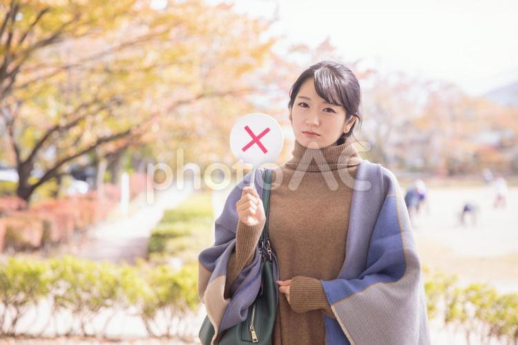 秋の公園でバツを作る女性 バツ,ダメ,秋の写真素材