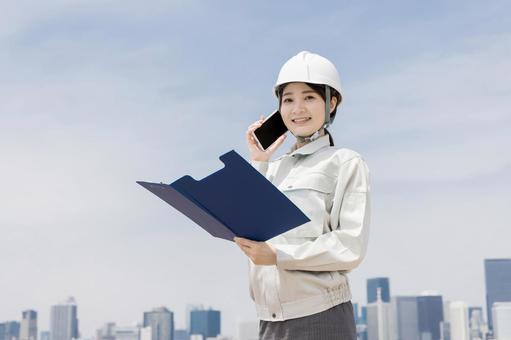 都会で働く作業員 都会で働く作業員 作業員,ビジネスウーマン,スマートフォンの写真素材