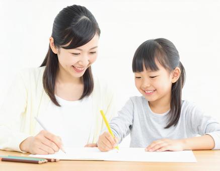 勉強をする小学生と女性 1 勉強をする小学生と女性 1の写真