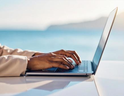 ノートパソコンでタイピングする手のアップの写真