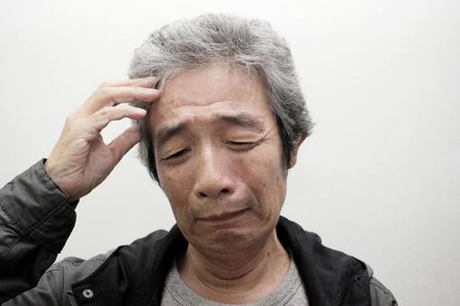 悩むシニア男性の写真