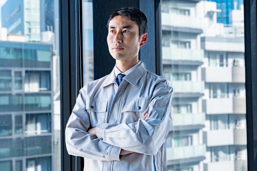 腕組みをする男性 腕組みをする男性 作業員,設計士,作業着の写真素材