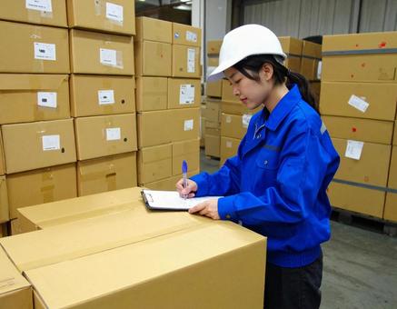 倉庫で在庫をチェックする女性作業員 倉庫で在庫をチェックする女性作業員の写真