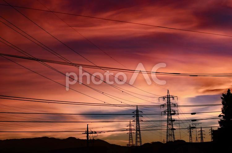 夕焼けの曇り空、高圧線のシルエット 夕焼け,シルエット,夕日の写真素材