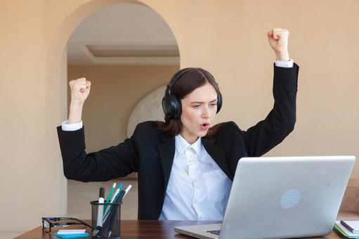 パソコンを見ながら喜ぶ女性 女性,外国人,ノートパソコンの写真素材