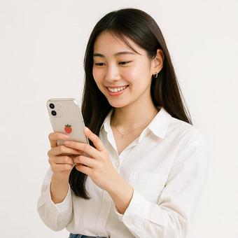 スマホを見つめて微笑む女の子 スマホを見つめて微笑む女の子の写真