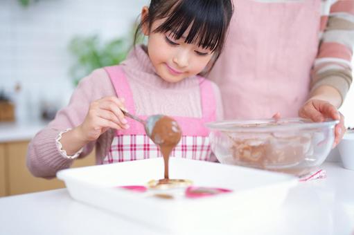 お菓子作りを楽しむ親子のクッキングシーン 女の子,チョコレート,スプーンの写真素材