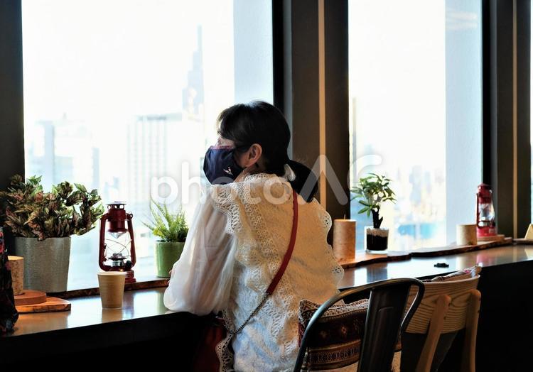 都市風景を眺めるマスク姿の女性 女性,都会,都市風景の写真素材