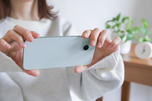 スマホを横向きで使う女性　動画視聴 スマートフォン,横向き,スマホの写真素材