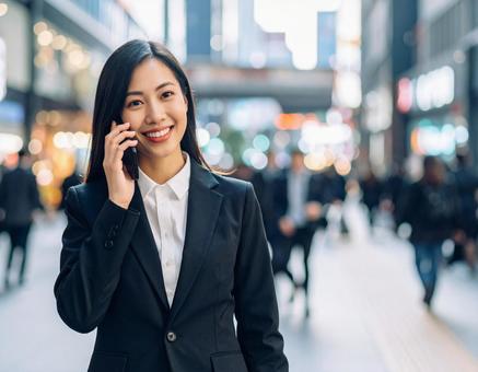 街中で通話する女性 街中で通話する女性の写真