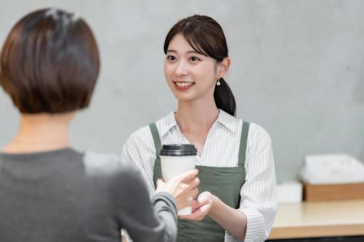 ドリンクを渡す女性 ドリンクを渡す女性 カフェ,店員,笑顔の写真素材