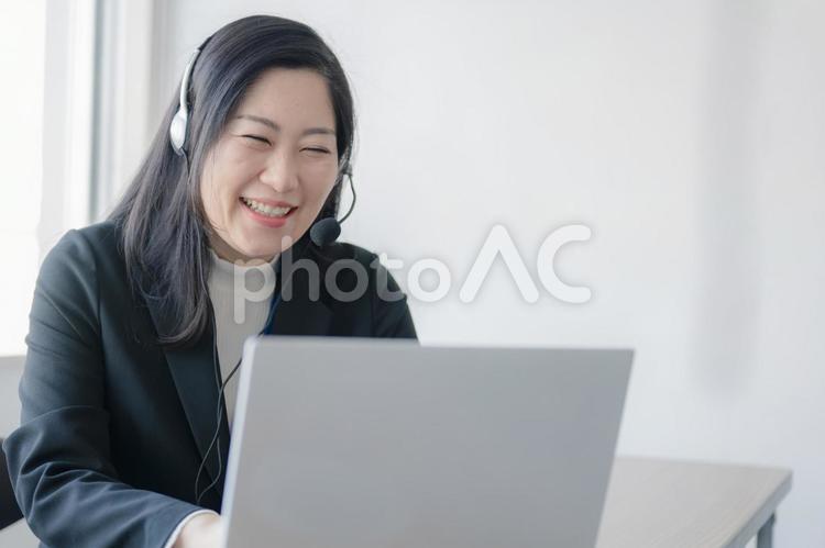 インカムと爆笑する女性(その４２) コールセンター,女性,オペレーターの写真素材
