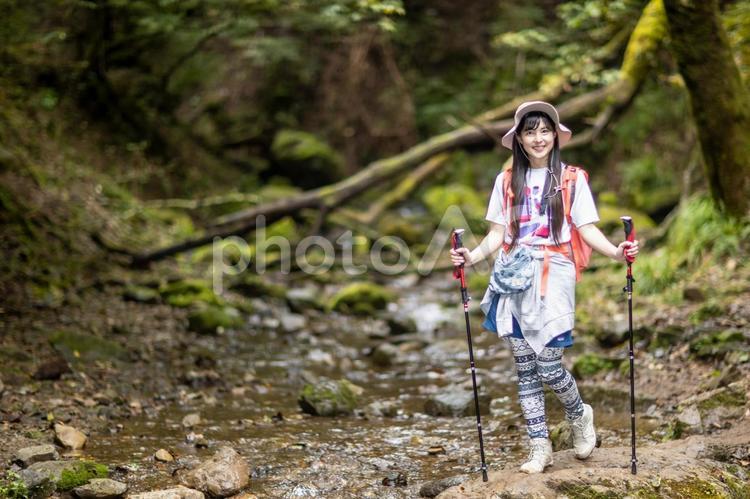 カメラ目線で笑顔で歩く女性 女性,歩く,岩の写真素材