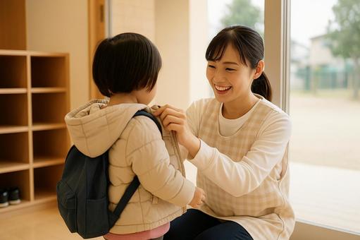 上着を着せる保育士 上着を着せる保育士の写真