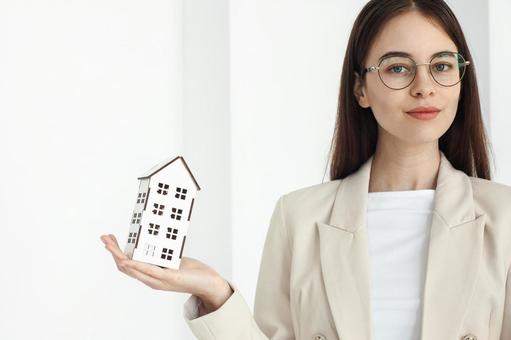 笑顔の女性スタッフと手のひらの模型 保険業,事務職,接客業の写真素材