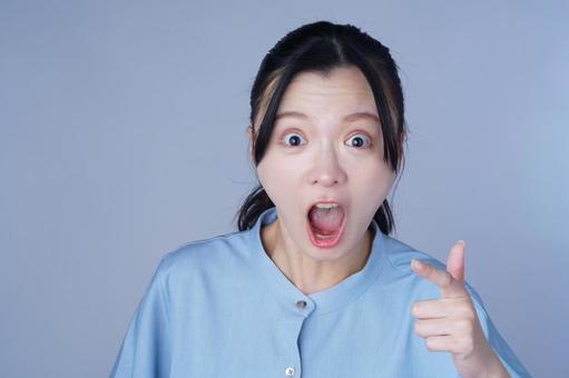 青い服の女性が驚いた表情 女性,驚く,指差しの写真素材