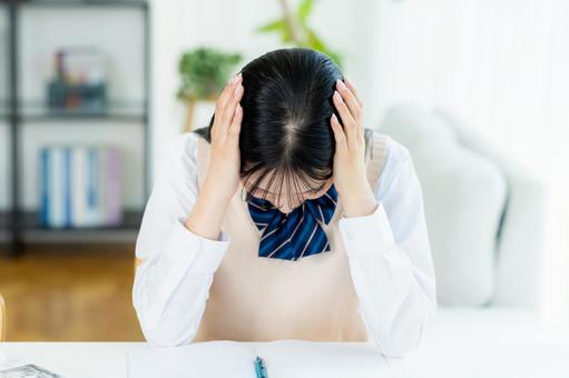 自宅で勉強中に悩む女子高生 自宅で勉強中に悩む女子高生の写真