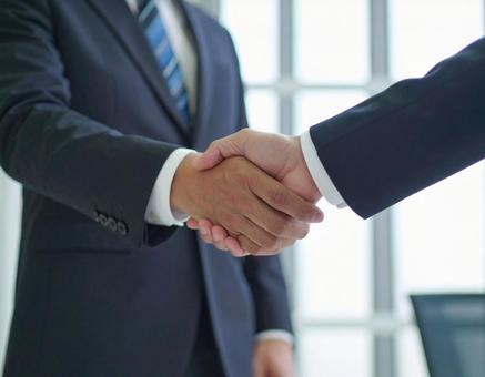 握手をするビジネスマンの手元 握手をするビジネスマンの手元の写真