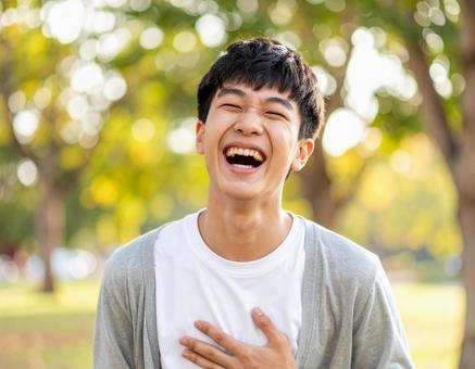自然の中で大笑いする男子高校生の笑顔 自然の中で大笑いする男子高校生の笑顔の写真
