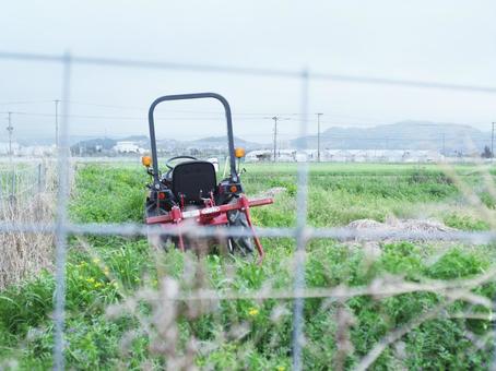 柵超しの耕うん機 柵超しの耕うん機の写真