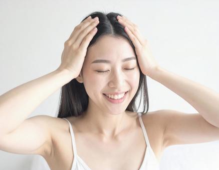 頭皮マッサージをする女性 頭皮マッサージをする女性の写真