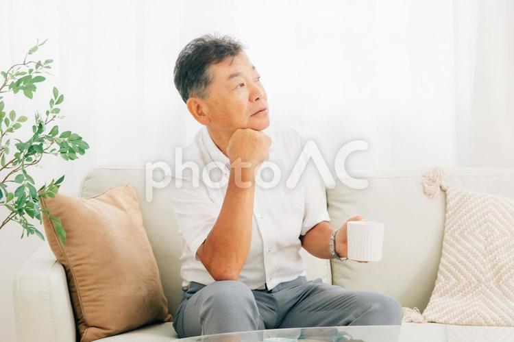 ソファでコーヒーを飲む高齢者男性 コーヒー,お茶,高齢者の写真素材